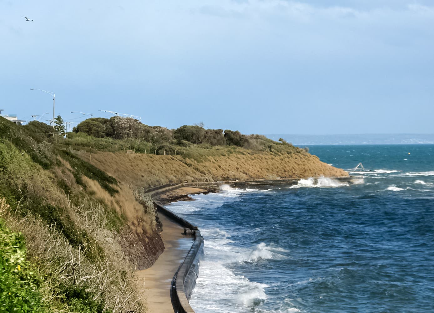 The Black Rock foreshore path and seawall on Port Phillip, with the scuttled Cerberus breakwater offshore