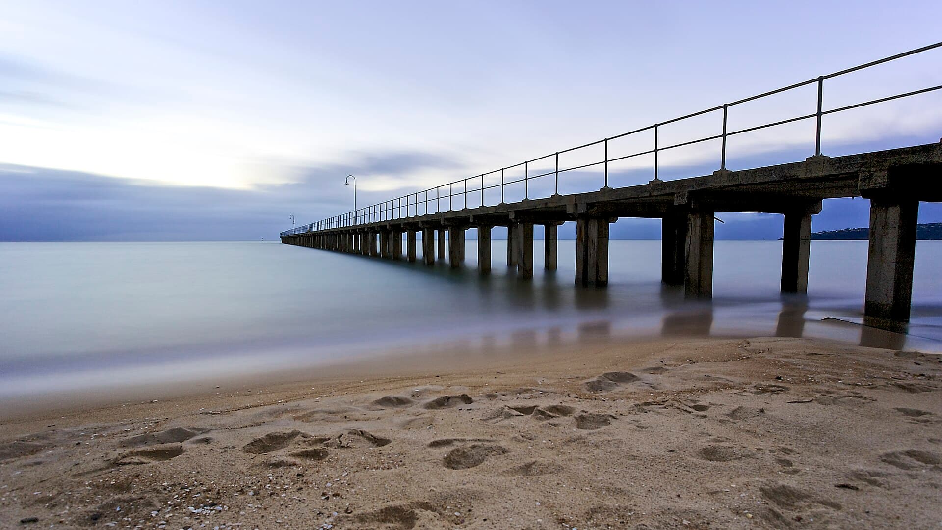 Jetty reaching out over the calm waters of Port Phillip from the sandy McCrae and Dromana foreshore