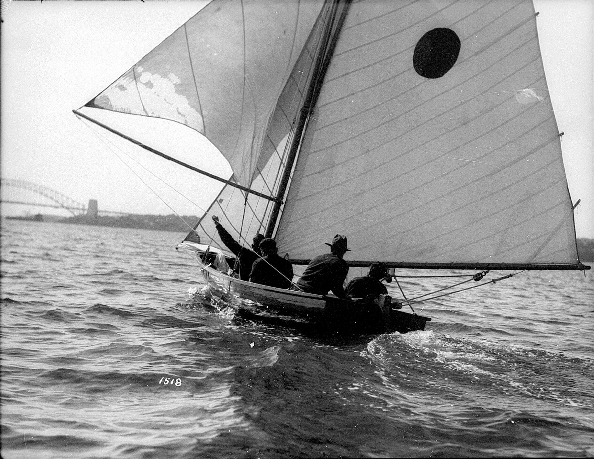 A sloop under sail on Sydney Harbour with the Harbour Bridge visible